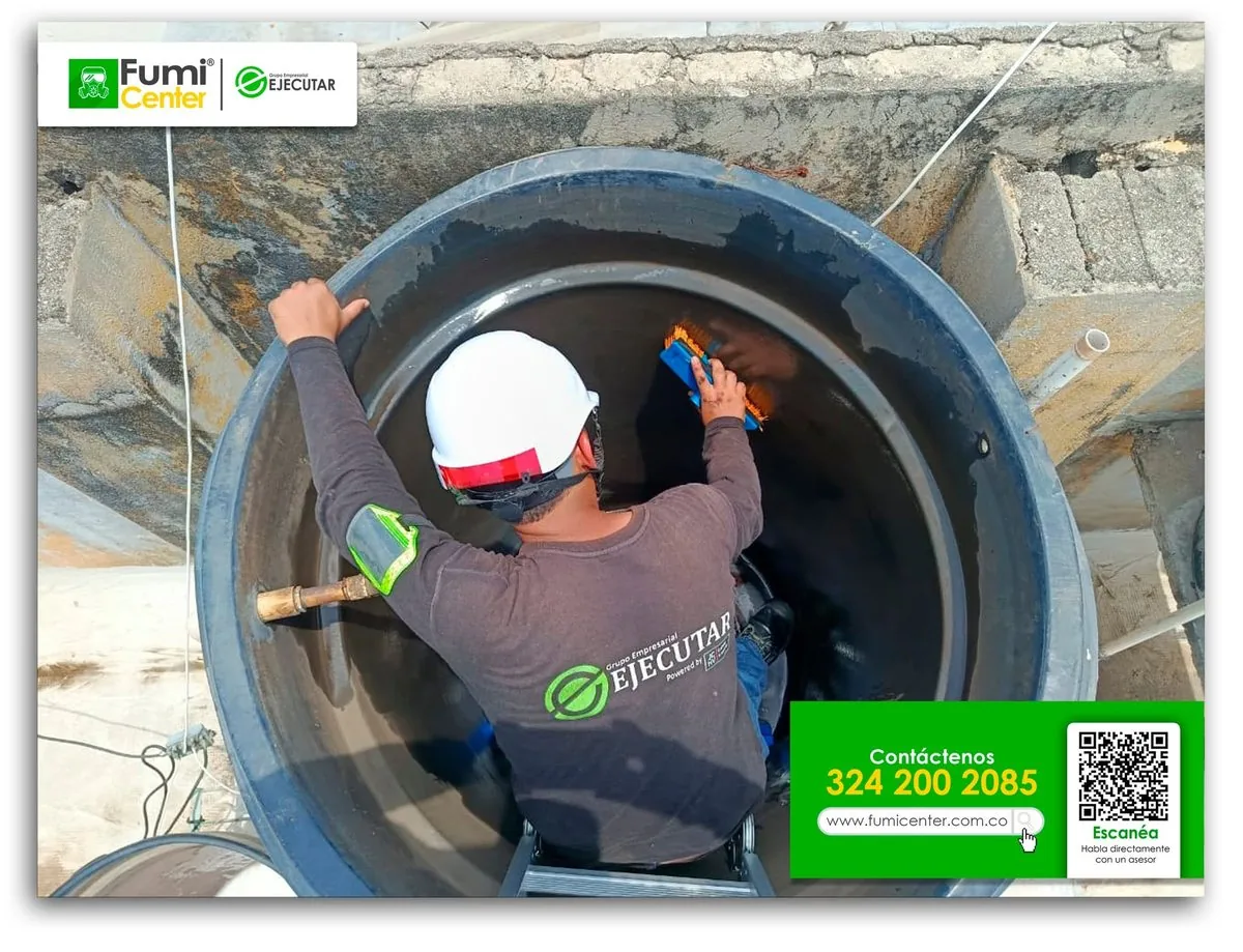 Técnico de FumiCenter con casco dentro de un tanque elevado plástico durante el cepillado